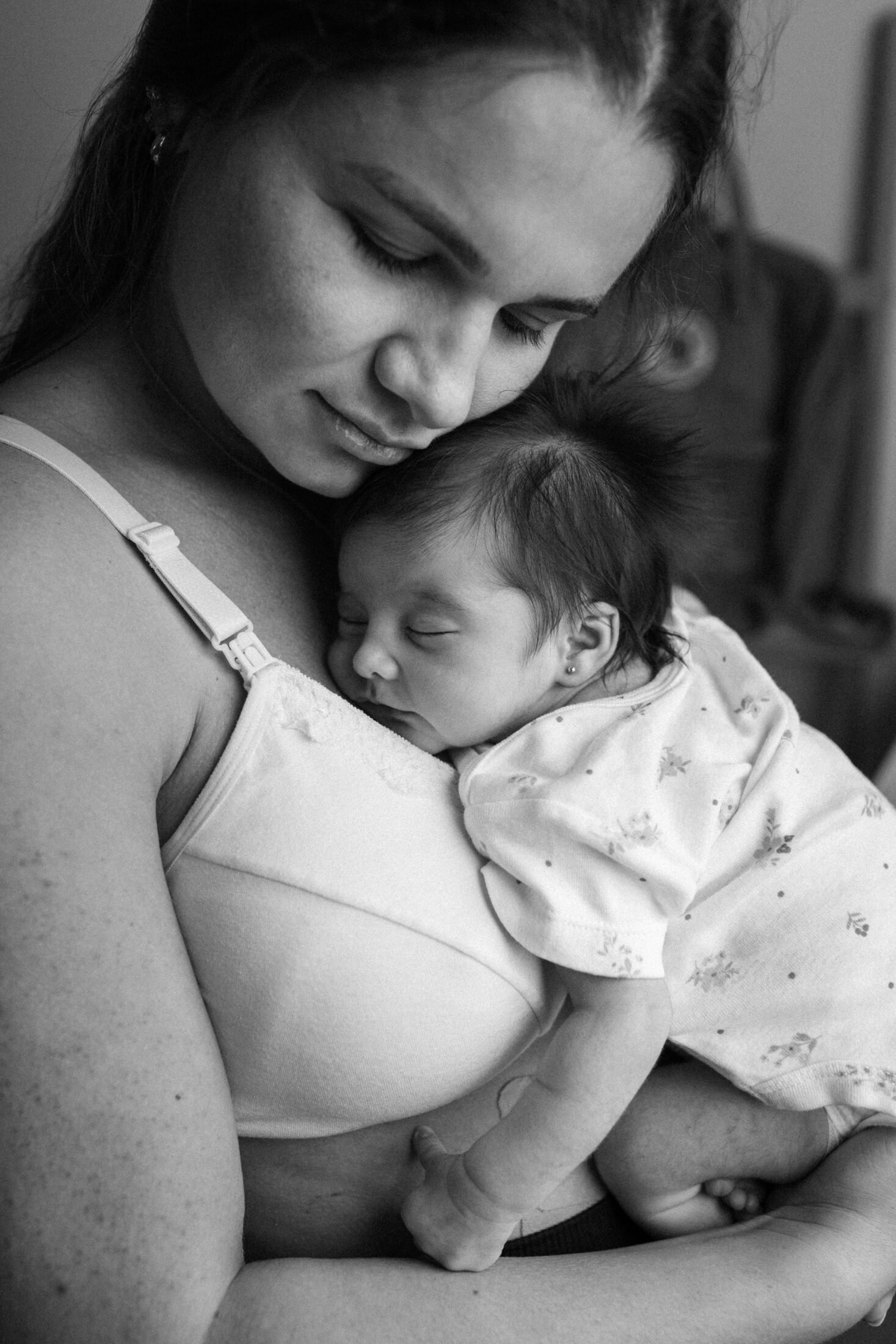 A mother holding her sleeping newborn close to her chest